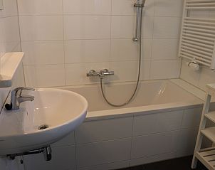 Stylish bathroom with bathtub in Holiday home Gortersmient 324, De Dennen, Texel for ultimate relaxation moments.