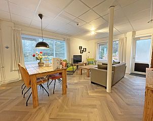 Bright and spacious dining room in Apartment Bos en Duin 04, De Dennen, Texel with wooden table and modern chairs.