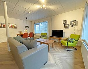 Stylish sitting area in Apartment Bos en Duin 04, De Dennen, Texel with flat-screen TV and colorful accents.