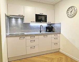 Modern kitchen in Apartment Bos en Duin 04, De Dennen, Texel with sleek white cabinets and built-in appliances.