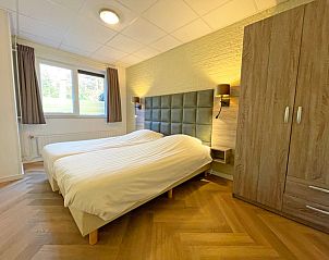 Spacious bedroom in Apartment Bos en Duin 04, De Dennen, Texel with soft lighting and large closet.