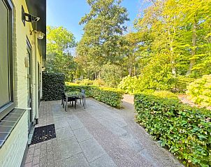 Exterior of Apartment Bos en Duin 06, De Dennen, Texel with green surroundings and inviting terrace.