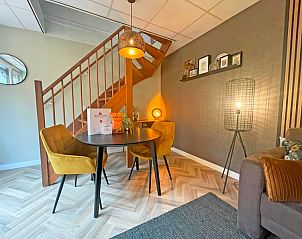 Essbereich im Appartement Bos en Duin 24, De Dennen, Texel mit Holztreppe und gemtlicher Beleuchtung fr stimmungsvolles Essen.