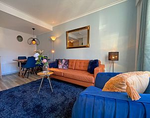 Dining area in Apartment Bos en Duin 27, De Dennen, Texel with wooden table and stylish chairs, ideal for cozy meals.