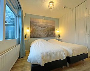Second bedroom in Apartment Bos en Duin 27, De Dennen, Texel with two single beds and fresh furnishings.