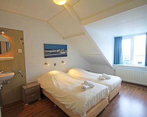 Attractive bedroom with two beds in Apartment Bos en Duin 33, De Dennen, Texel for a good night's sleep.
