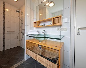 Zonnig terras van Appartement Bos en Duin 37, De Dennen, Texel met comfortabele zitplaatsen en groene omgeving.