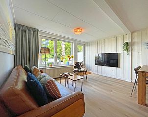 Gerumiges Wohnzimmer im Apartment Bos en Duin 20, De Dennen, Texel, mit bequemen Sitzgelegenheiten und einem groen Fenster.