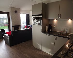 Moderne Kche im Ferienhaus Gortersmient 210, De Dennen, Texel mit groem Wohnzimmer und Kamin.