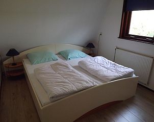 Gerumiges Schlafzimmer im Ferienhaus Gortersmient 210, De Dennen, Texel mit Doppelbett und Tageslicht.