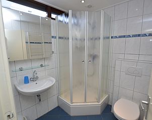 Moderne badkamer in Vakantiehuis de Parel 160, De Dennen, Texel, uitgerust met douche, wastafel en toilet voor comfort en gemak.