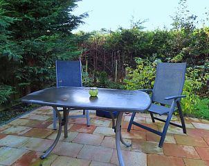 Quiet terrace of Dunkonijn vacation home, De Dennen, Texel, surrounded by green nature.