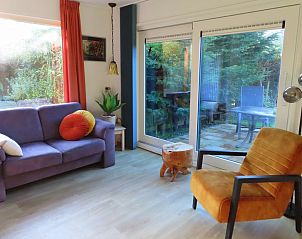 Cozy living room of Dunkonijn vacation home in De Dennen, Texel overlooking the garden.