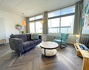 Bright living room of Apartment Bos en Duin 02, Texel, with large windows and an inviting seating area.
