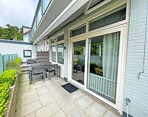 Private terrace of Apartment Bos en Duin 02, De Dennen, Texel with seating and views of nature.