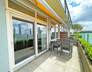 Sonnige Terrasse des Appartements Bos en Duin 03, Texel, mit Gartenmbeln und Blick auf die Natur.