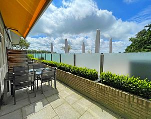 Private Terrasse des Appartements Bos en Duin 03, De Dennen, Texel, mit Sitzgelegenheiten und grner Umgebung.