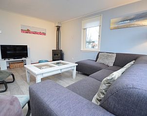 Stylish living room in Holiday home de Parel 214, De Dennen, Texel, with a cozy fireplace.