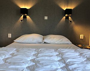 Gemtliches Schlafzimmer im Ferienpark de Bremakker - Bosveld 121, De Dennen, Texel mit bequemem Bett und warmer Beleuchtung.