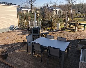 Gerumige Terrasse im Ferienpark de Bremakker - Bosveld 121, De Dennen, Texel mit Esstisch und Blick auf die natrliche Umgebung.