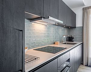 Modern kitchen in vacation home Tormentil, De Dennen, Texel, with sleek finish and lots of light.