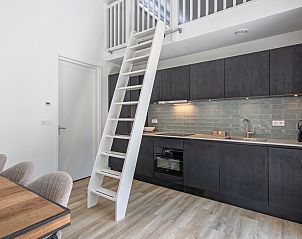 Open kitchen and dining area with stairs to the loft in vacation home Tormentil, De Dennen, Texel.
