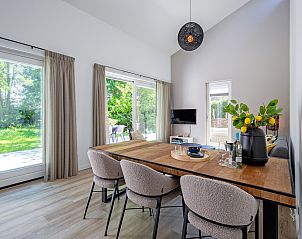Cozy dining room with large windows in vacation home Tormentil, De Dennen, Texel, ideal for family dinners.