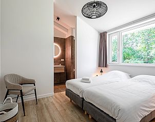 Bedroom with ensuite bathroom in vacation home Tormentil, De Dennen, Texel, overlooking nature.
