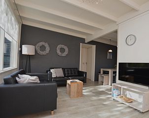 Stilvolles Wohnzimmer von Bungalow 't Hoogelandt 24, De Dennen, Texel mit modernen grauen Sofas und viel Tageslicht.