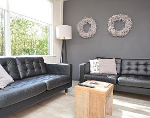 Essecke im Bungalow 't Hoogelandt 24, De Dennen, Texel mit Holztisch und bequemen Sitzgelegenheiten fr die Familie.