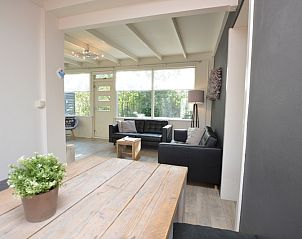 Gemtliche Sitzecke im Bungalow 't Hoogelandt 24, De Dennen, Texel mit modernen Sthlen und Gartenblick.