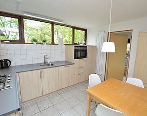 Kompakte Kche im Ferienhaus de Parel 286, De Dennen, Texel, mit Esstisch aus Holz.