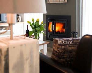 Cozy fireplace in Bungalowpark Gortersmient vacation home 278, De Dennen, Texel. Warm atmosphere on the Wadden Islands.