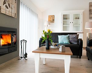 Cozy sitting area with fireplace in Bungalowpark Gortersmient vacation home 278, De Dennen, Texel. Relaxation on the Wadden Islands.