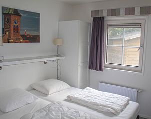 Slaapkamer met tweepersoonsbed in Twaalfpersoons vakantiehuis, De Dennen, Texel.