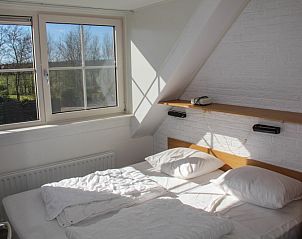 Lichte slaapkamer in Twaalfpersoons vakantiehuis, De Dennen, Texel met uitzicht.