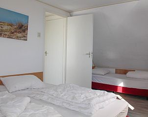 Ruime slaapkamer met extra bed in Twaalfpersoons vakantiehuis, De Dennen, Texel.