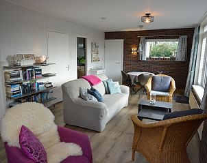 Ruime woonkamer in vakantiehuis Tempelierweg 32 - Bergland, Texel met boekenplank.