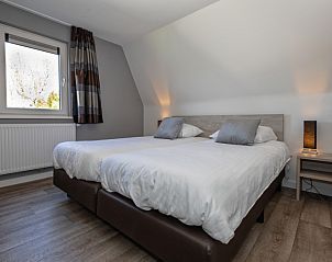 Knusse zithoek met open haard in Bungalowpark Gortersmient vakantiehuis 288, De Dennen, Texel, perfect voor koude avonden.