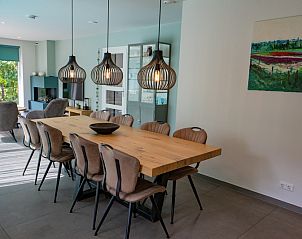 Dining area in Holiday home the Pearl 174, Texel with stylish wooden table and hanging lamps.