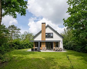 Vakantiehuis de Parel 180 in De Dennen, Texel, omgeven door groene natuur en een ruim terras.