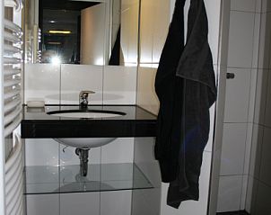 Modernes Badezimmer im Ferienhaus Gortersmient 354 mit Waschbecken und Spiegel in De Dennen Texel.