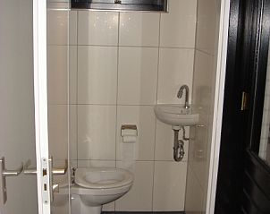 Kompakte Toilette im Ferienhaus Gortersmient 354 mit gefliestem Boden und Fenster in De Dennen Texel.