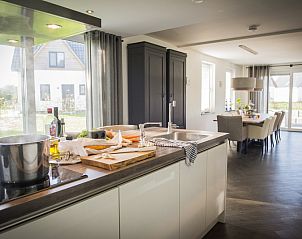 Spacious kitchen and dining room in Villa bij Zee, Bungalowpark 't Hoogelandt, De Dennen, Texel overlooking the garden.