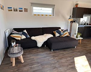 Spacious sitting area in Holiday Park de Bremakker - Bosveld 141, Texel with modern decoration and wooden floor.