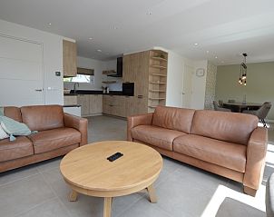 Moderne woonkamer in Tempelierweg - Kogermient 18, De Dennen Texel, met leren banken en open keuken.