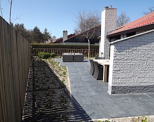 Gerumige Terrasse des Ferienhauses Gortersmient 320, De Dennen, Texel mit modernem Gartentisch und Sthlen, umgeben von Natur.