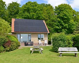 Ferienhaus 't Wambas in De Dennen, Texel mit sonniger Terrasse und grner Umgebung.