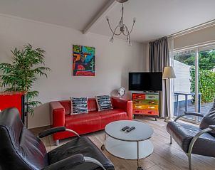 Cozy living room of Bungalowpark 't Luwe Land - Texelfan, De Dennen, Texel. Modern decor with colorful accents.