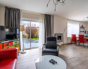 Bright living room of Bungalowpark 't Luwe Land - Texelfan, Texel. Large windows overlooking the garden in De Dennen.